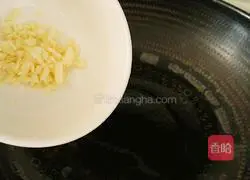 Heat vegetable oil in a wok until about 70 percent hot, then add the minced garlic.